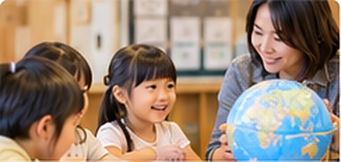 地球儀を見る子どもたちと先生