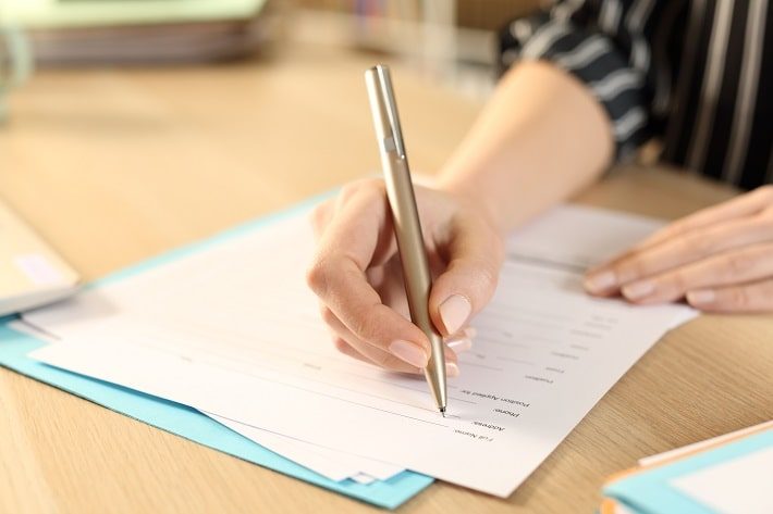 新学期の初日に学校からもらってきた必要提出書類に記入している様子
