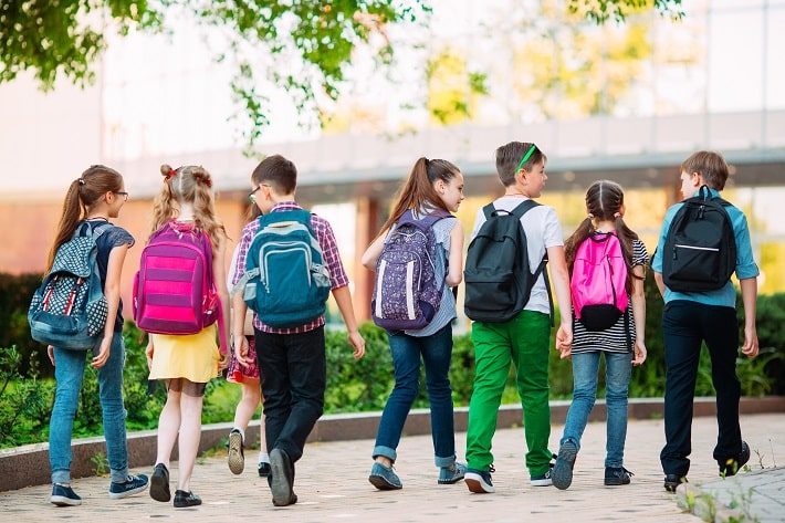 リュックを背負ってみんなで話しながら学校に登校している様子
