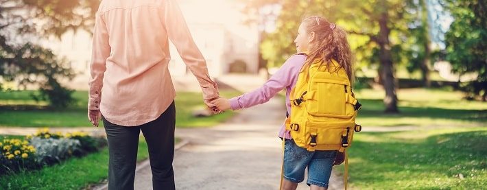 母と子が手を繋いで安全に歩いている様子。